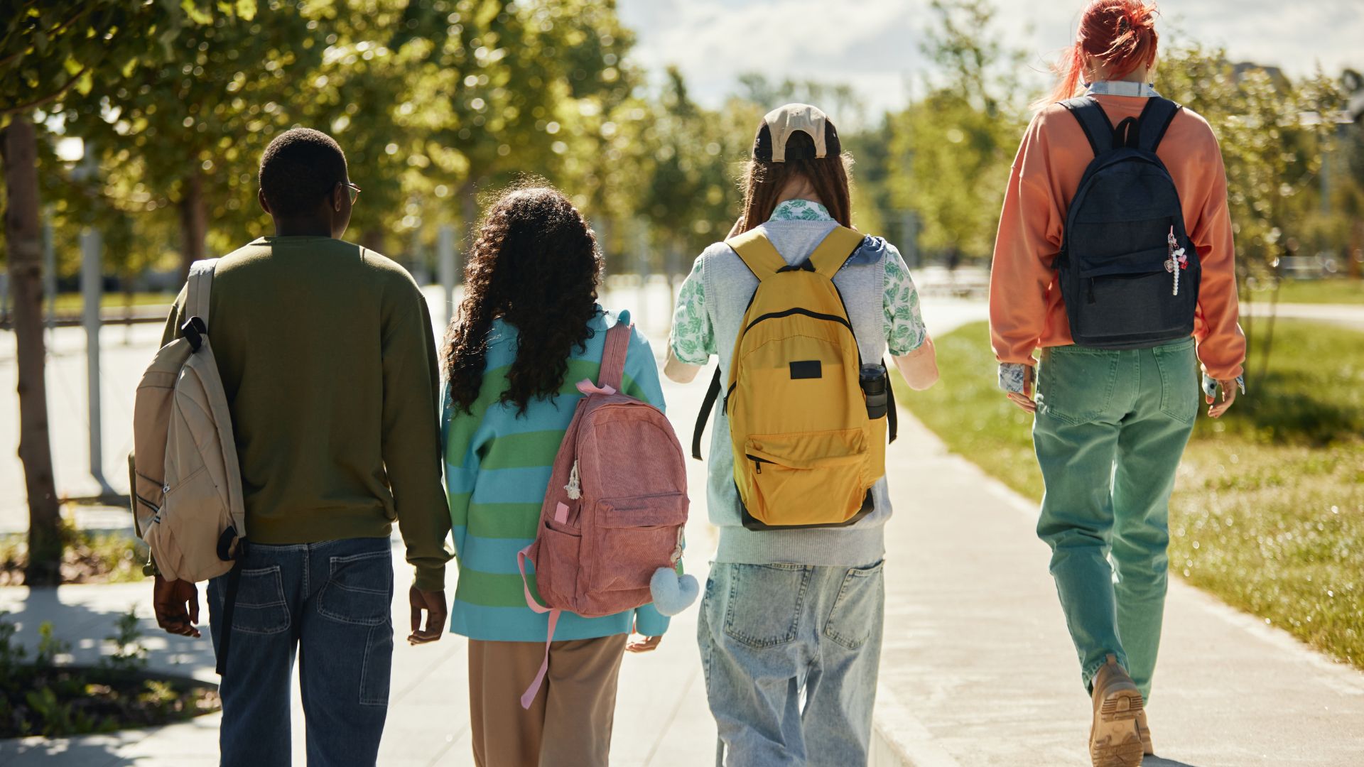 Rear view of diverse group of teenage students with backpacks