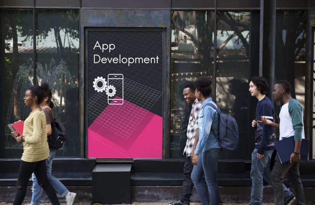 Pedestrians walking past a street-side digital billboard.