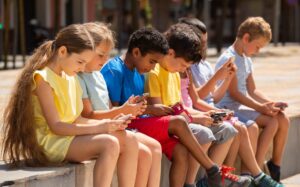 Children using mobile phones in public as Australia debates social media restrictions for users under 16.