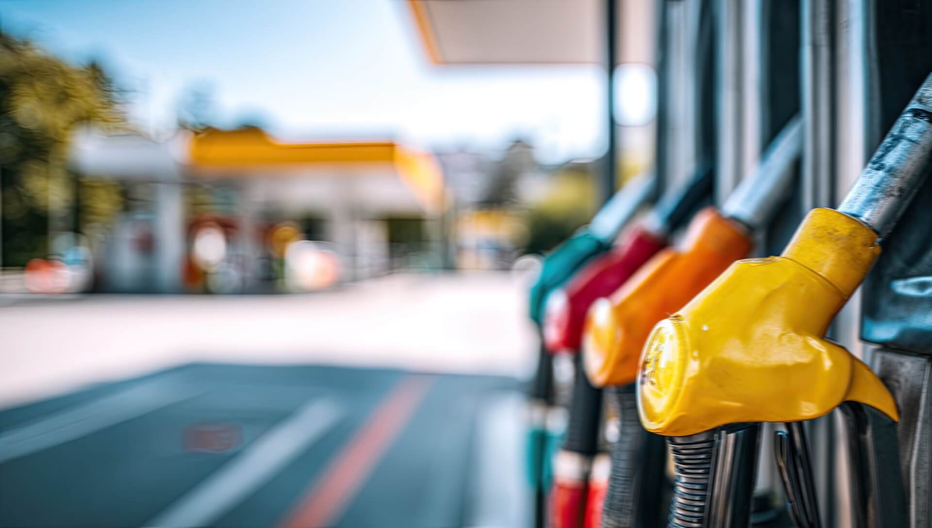 Colorful fuel pump nozzles at a gas station.