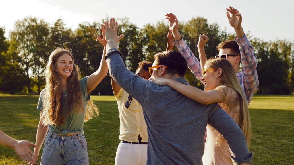 Friends high-fiving in a park