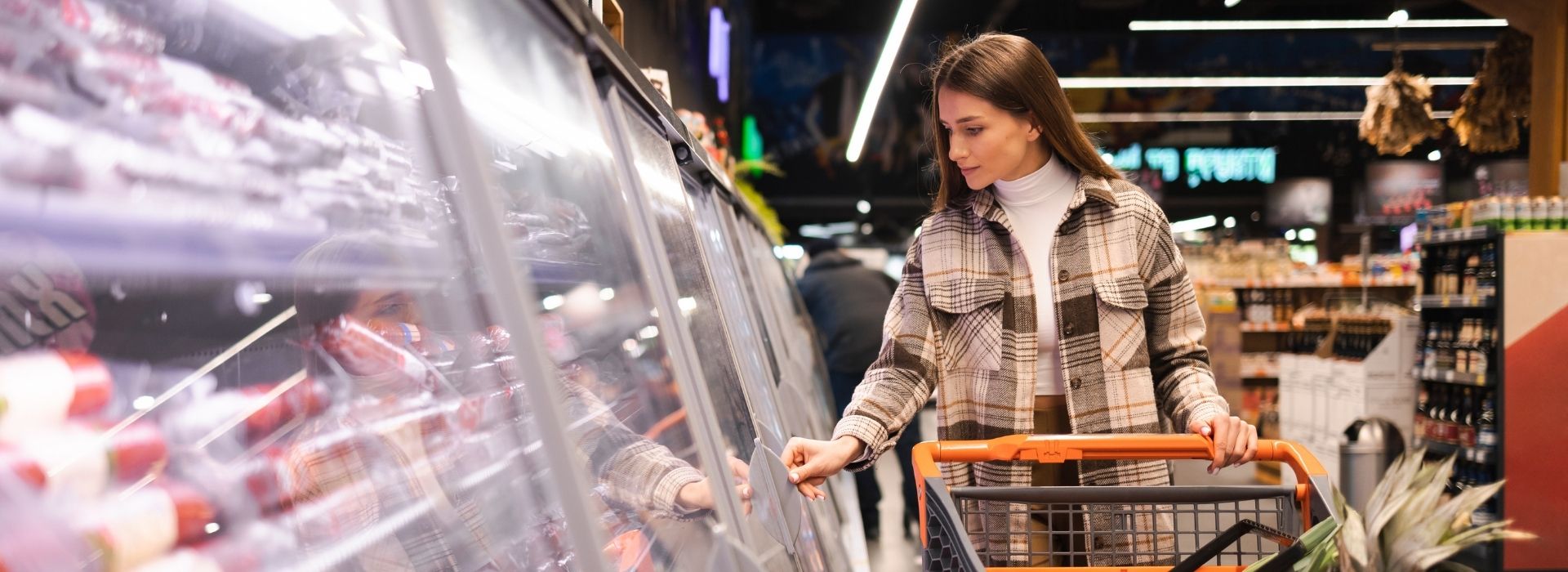Woman shopping in a grocery store meat section