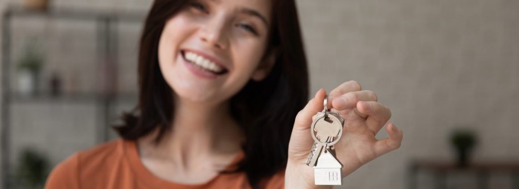 Smiling female first home buyer holding the keys