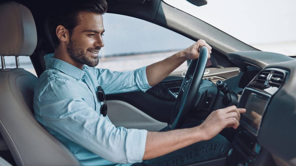 Man driving car and turning on music