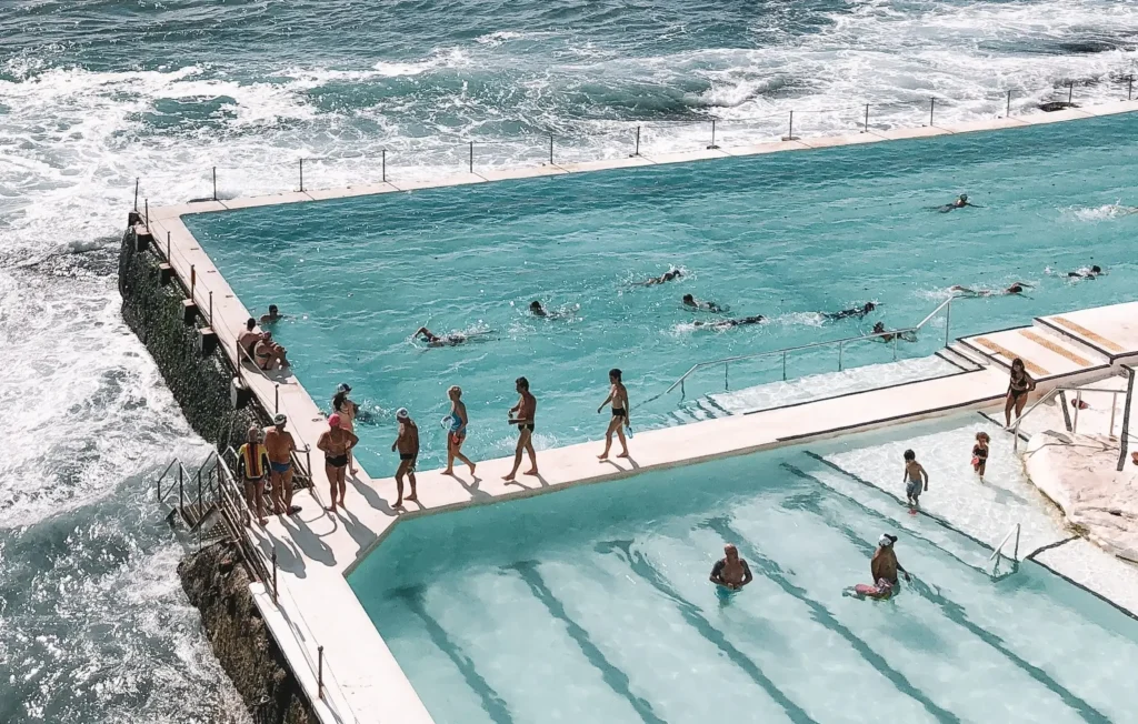 People swimming at Bondi Icebergs pool next to the sea