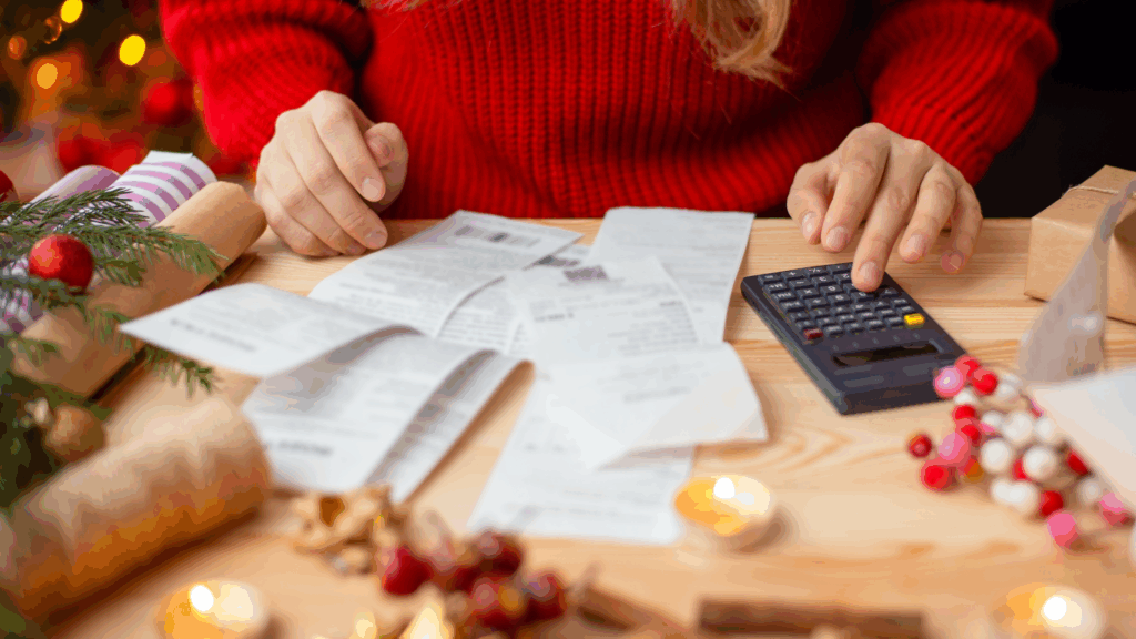 Woman sitting at the table, checking her bills after buying everything for Christmas. Winter holidays shopping, expensive time of the year