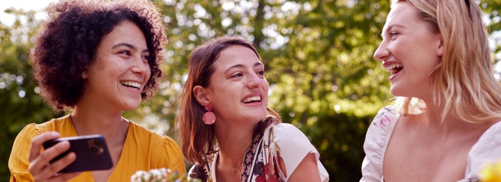Group of three women smiling at each other