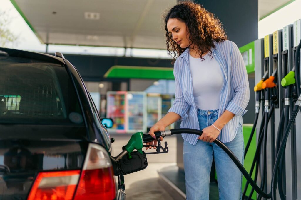 Woman refueling her car at a gas station