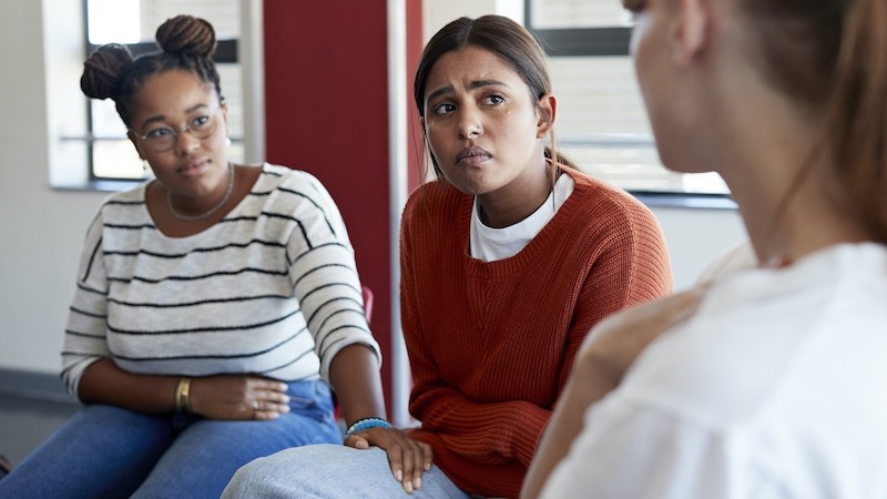 Sad woman crying while looking at female friend