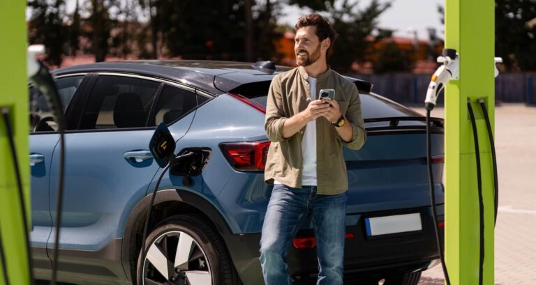 Driver using a smartphone while waiting for an electric vehicle to charge