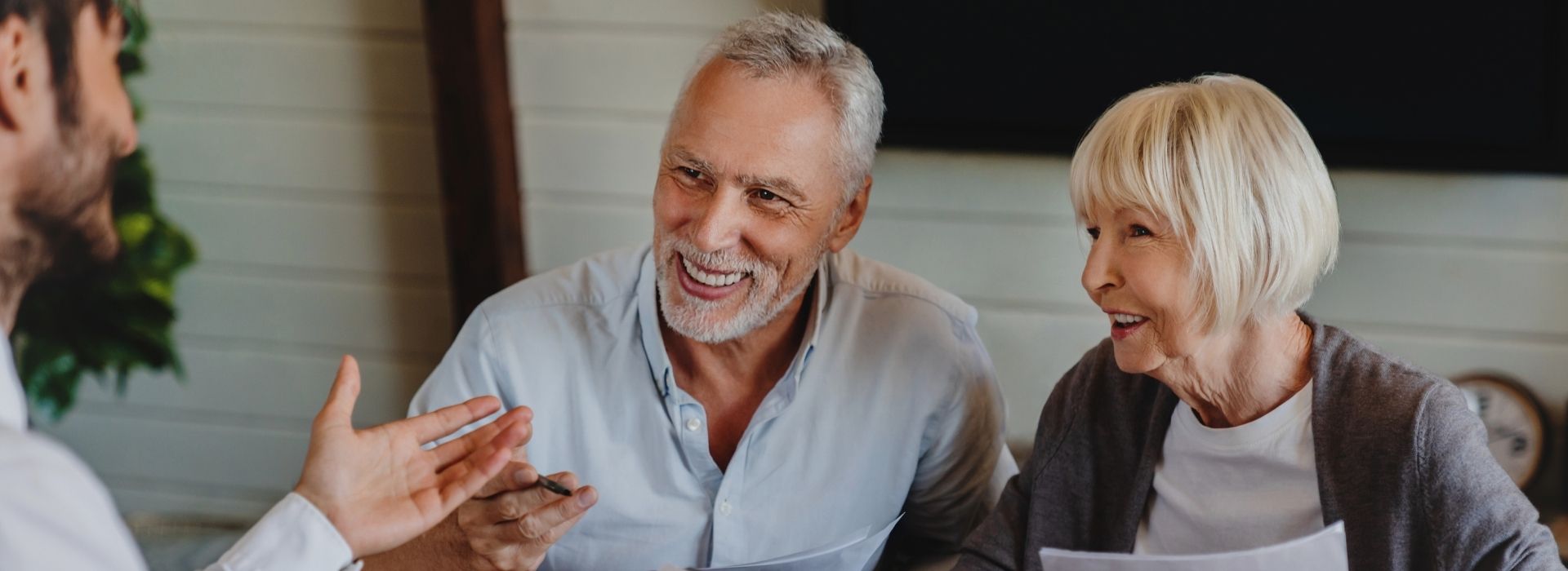 Elderly couple speaking to a man in an office