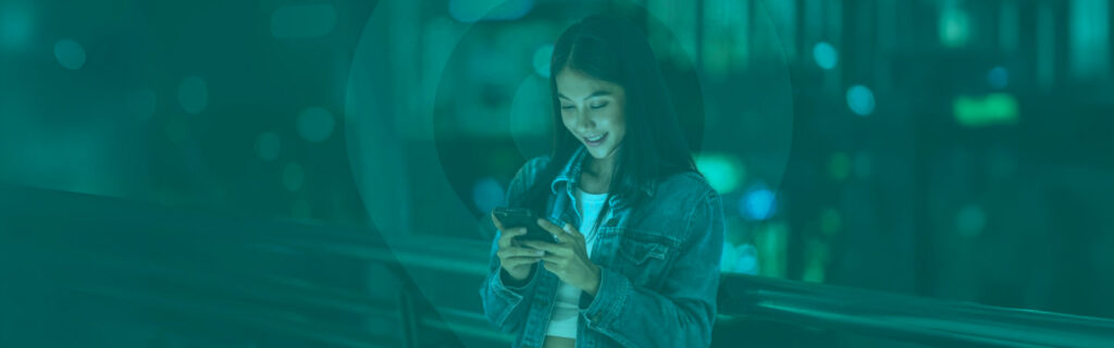 Young woman smiling looking at her mobile phone