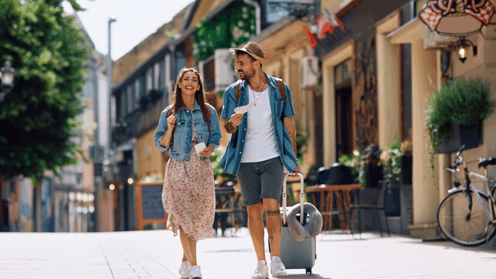Happy couple of tourists walking in the city while traveling together.