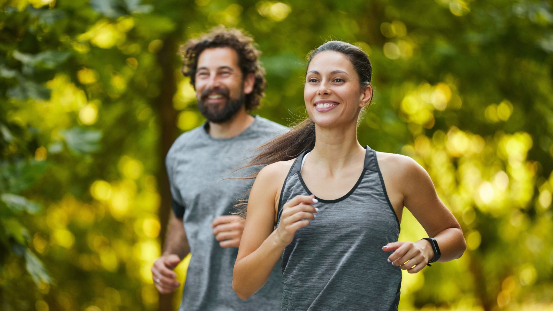 In a serene park, a man and woman run together