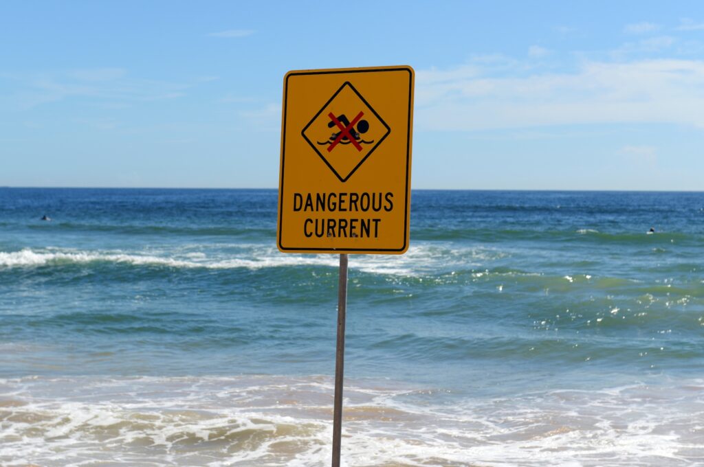 Dangerous Current sign, warning swimmers and surfers of the rough water where they are recreating off the beach