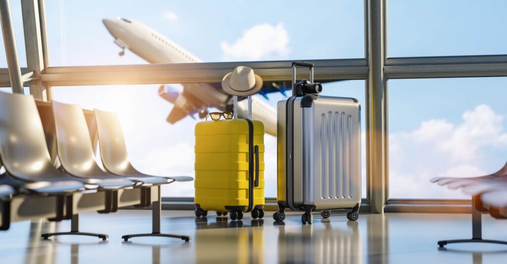 Two suitcases in the airport departure lounge, airplane in the blurred background, summer vacation concept, traveler suitcases in airport terminal waiting area