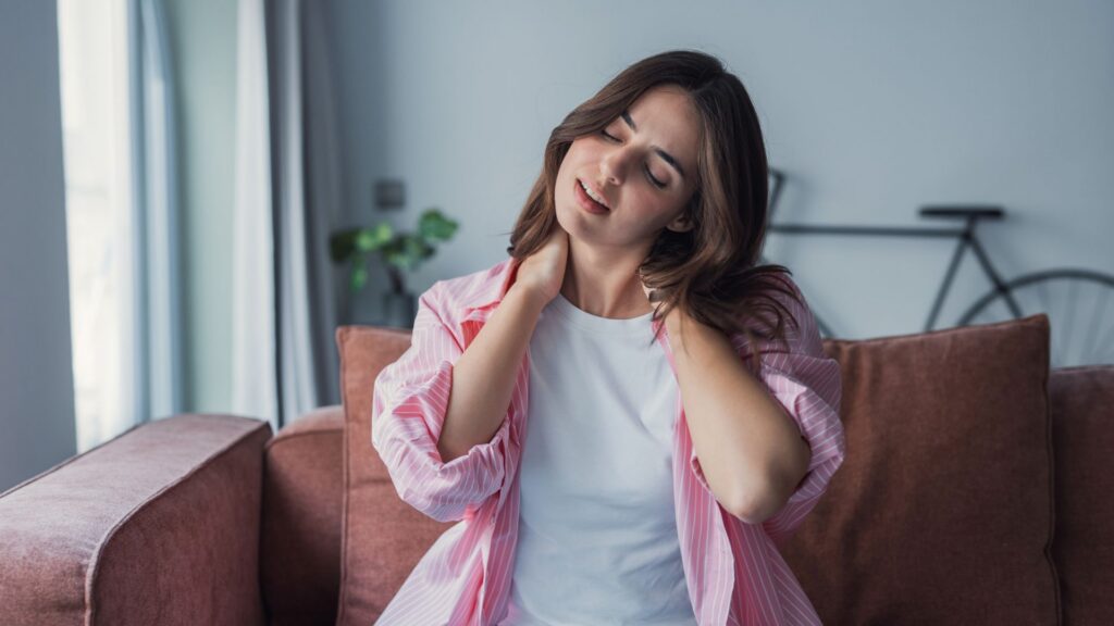 Tired young woman touch neck suffer from muscular spasms