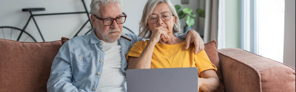 retired couple looking at their laptop