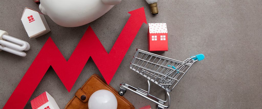 Upwards arrow with shopping cart, house, bulb and piggy bank for rising cost of living