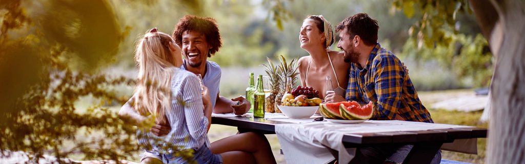 group of laughing people at a picnic table