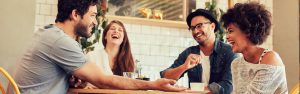 Friends laughing at a table in a cafe