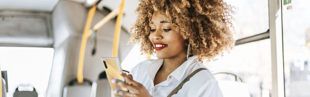 Woman on bus completing a survey on mobile