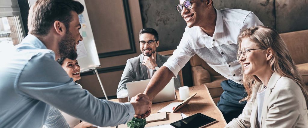 colleagues shaking hands in meeting