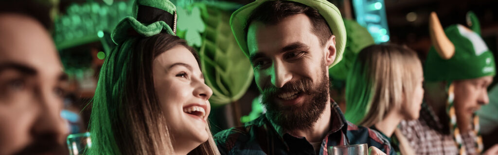 People in a bar dressed in green and laughing