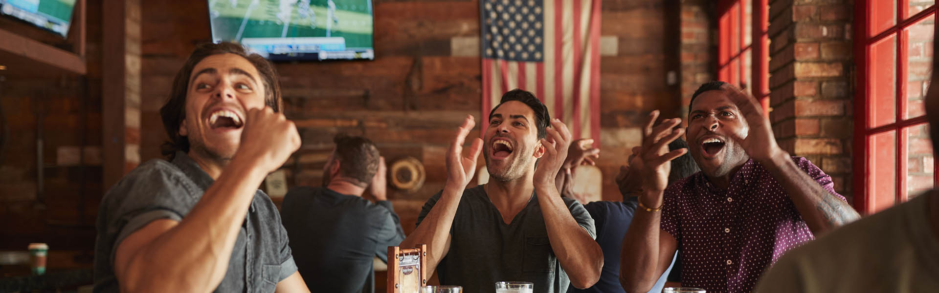 group of friends watching american football in a bar