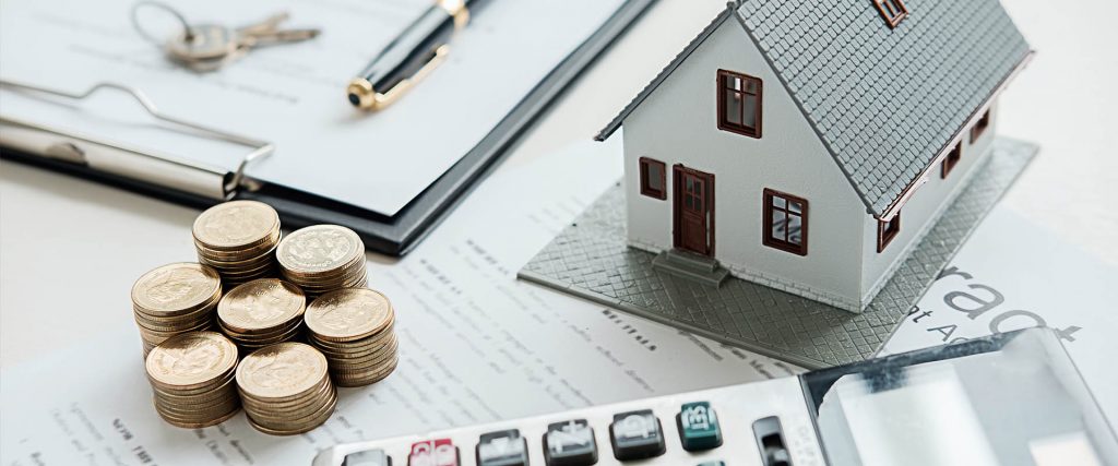 house model with money and calculator on a desk