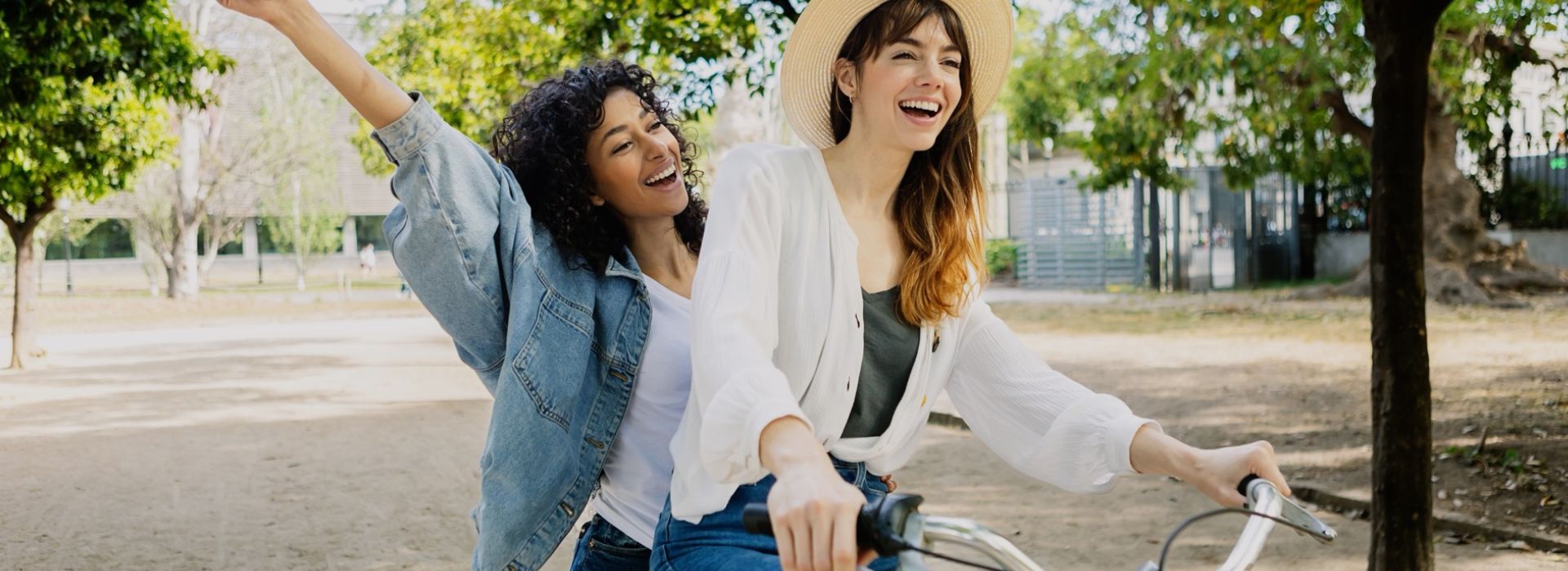 two happy friends riding on a bike