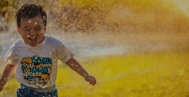 boy happily running on the rain