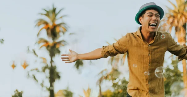 asian man happily smiling arms spread