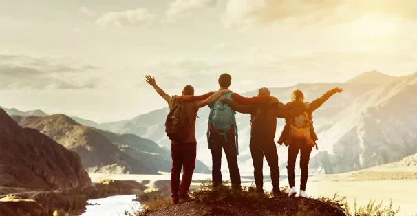 back view of friends in the mountain in sunset setting