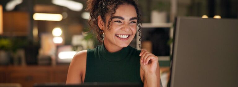 woman happily looking at computer