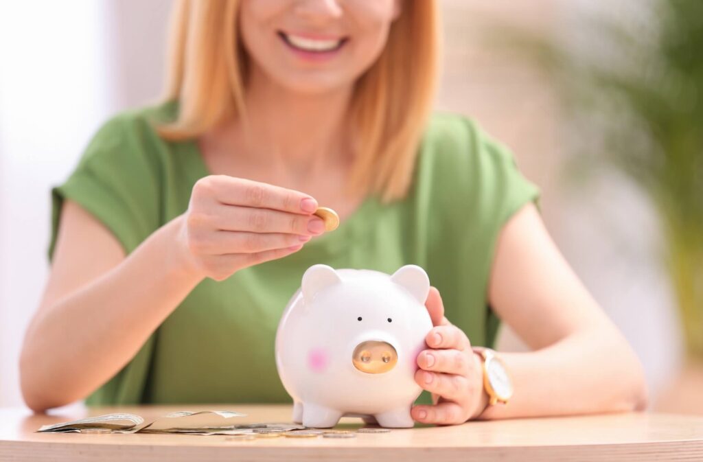 Woman with piggy bank and money at table, closeup