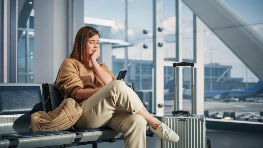 Airport Terminal: Woman Waits for Flight, Uses Smartphone